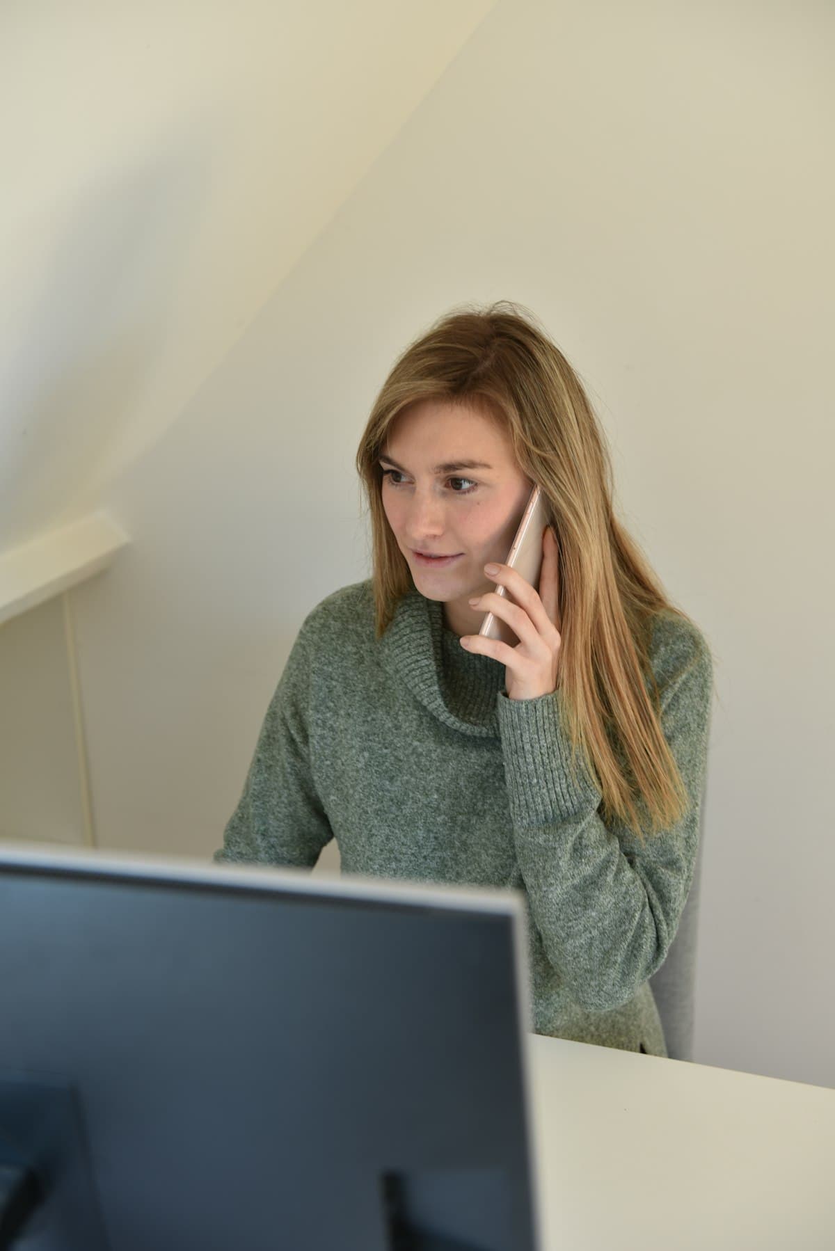 Mujer profesional atendiendo una llamada telefónica en su escritorio de oficina