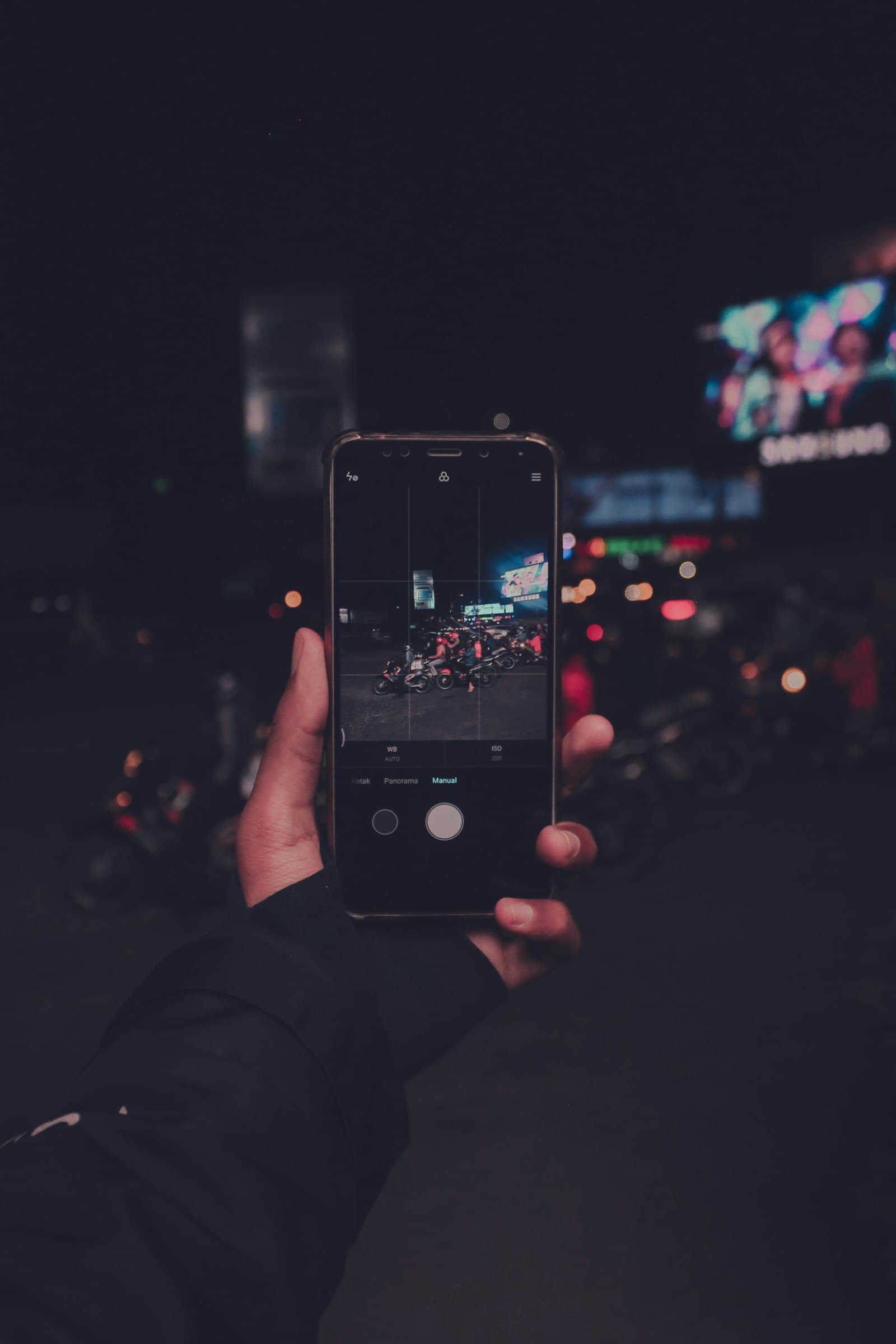 Persona utilizando una aplicación móvil de noche en la ciudad